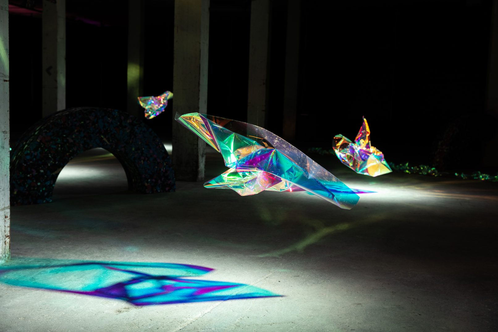 three floating multi coloured objects, dark basement, light with spots, beautiful blue shades