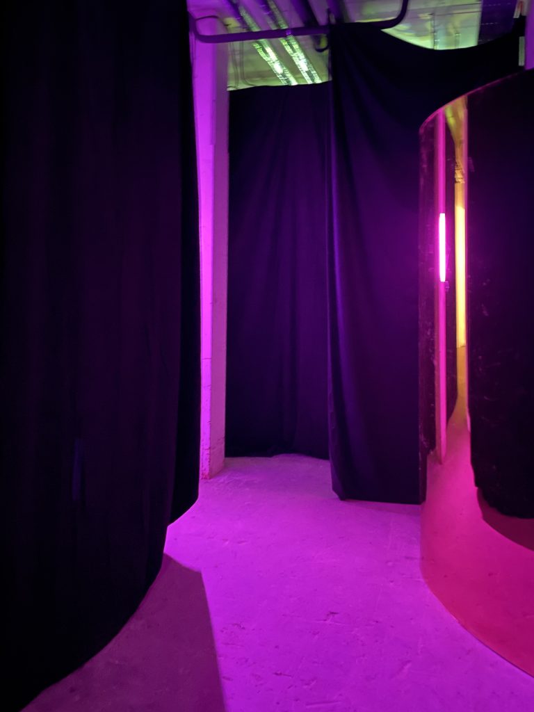 mysterious entrance, mirror, pink light, black curtains