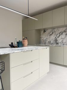 maatwerk keuken met grijsgroene fronten en arabescato blad, kookeiland met lades en ingefreesde greep door FELD interieurarchitecten Amsterdam